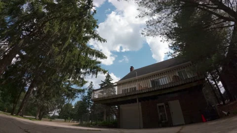 Timelapse clouds pass quickly behind suburban home. 스톡 동영상 230015282