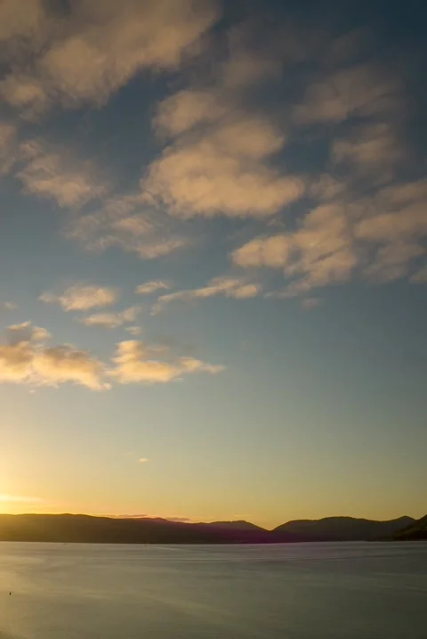 Timelapse Of Clouds Passing And Sun Setting Over A River - Vertical Video. Video stock 172061260