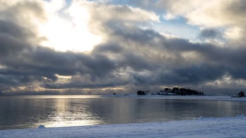 Timelapse of clouds passing over bay and snow covered beach in winter Stock Footage 91366187