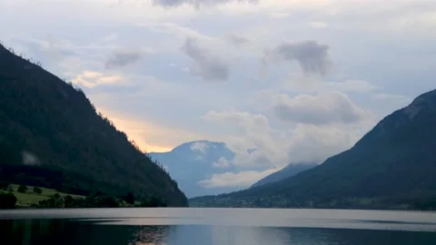 Timelapse of clouds passing through the mountains by a lake Stock Footage 152971742