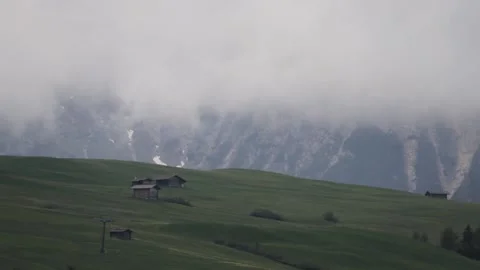 Timelapse of clouds passing by in the valley of siusi with cabins on the hil Stock Footage 211331810