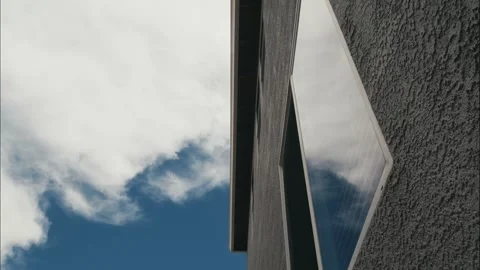 Timelapse of clouds reflecting in a modern home's window on a sunny day Stock Footage 314468911