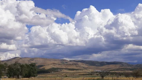 Timelapse - Clouds roll rapidly over hills clouds shadows move over ground Stock Footage 219441027