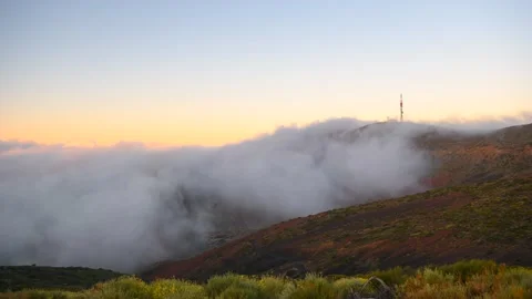 Timelapse of clouds rolling down volcanic mountain slope at sunset, Tenerife Stock Footage 335018034