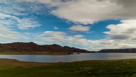 Timelapse of clouds rolling over fields and mountains along the lake Stock Footage 73011495