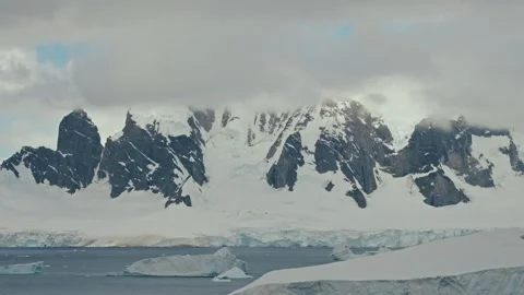 Timelapse of Clouds Rolling Over Jagged Rocky Antarctic Peaks Above Ice Shelf Stock Footage 334078784