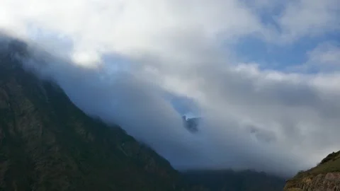 Timelapse of clouds rolling over a rugged mountain peak Stock Footage 318194675