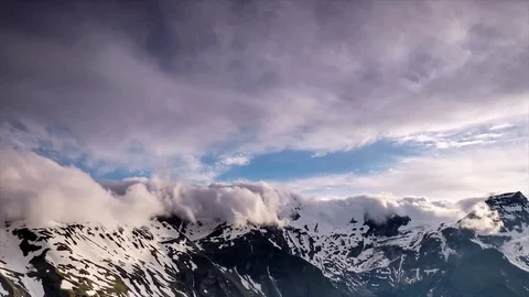 Timelapse of clouds rolling over snowy mountain peaks Stock Footage 94838024