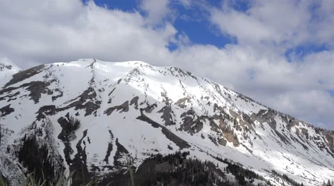 Timelapse-Clouds-Shadows move over snow capped mountain Stock Footage 63250014