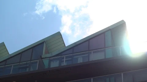 Timelapse clouds speeding past the sun over modern apartment rooftops Stock Footage 101647740