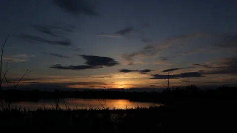 Timelapse of clouds at sunset over a lake in Alberta Video stock 90833584