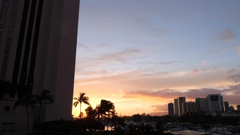 Timelapse of clouds at sunset through tropical palm trees buildings in Hawai Video stock 122438104