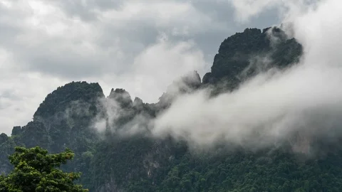 Timelapse of clouds surronding the cliff. Fog revealing mountain. Stock Footage 112166537