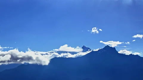 Timelapse Clouds swirl over blue mountains, snowy peak in the distance. Mustang Stock Footage 155264127