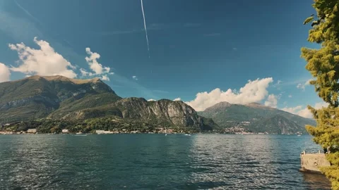 Timelapse of cloudy Lake Como panorama with white clouds moving over water. Stock Footage 324839639