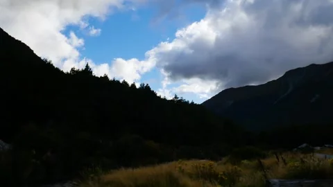 Timelapse of cloudy rolling over forest mountains in shadow Stock Footage 254157528
