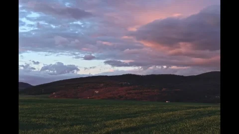 Timelapse of colorful clouds over fields and hills during sunset 스톡 동영상 273692298