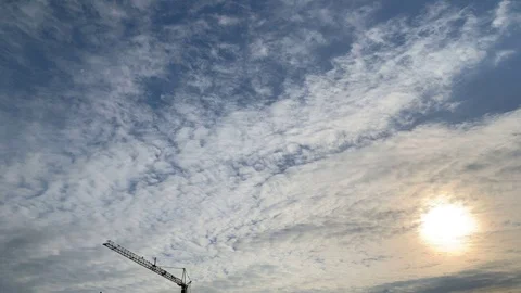 Timelapse construction crane in front of passing clouds at sunset Stock Footage 109104667