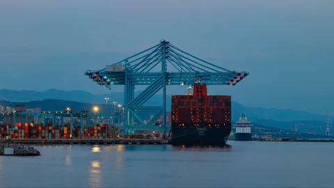 Timelapse of container ship loading operations at a busy port during twilight Stock Footage 333301868