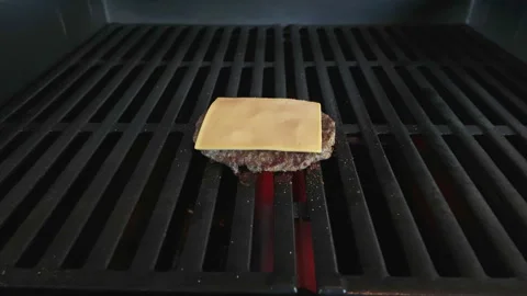 Timelapse cooking Cheeseburger on grill with grates show juices rise up and meat Stockbeeldmateriaal 337182310