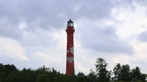 Timelapse of coulds rolling above a lighthouse on a windy day Video stock 257133015