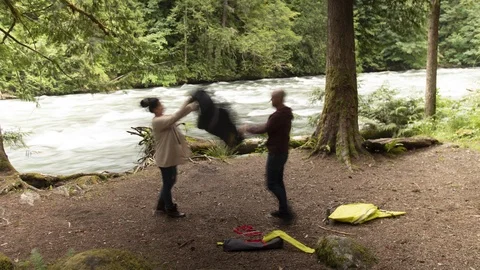 Timelapse of Couple Setting Up a Small Camping Tent Next to a Fast Flowing River Stock Footage 91403798