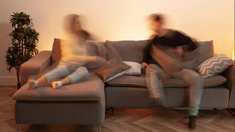 Timelapse of couple staying at home, using phones, siting on sofa at home Stock Footage 126586124