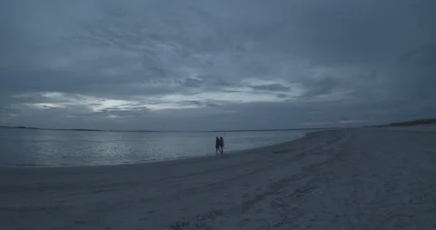 Timelapse of Couple Walking on Beach at Dusk Stock Footage 153038369