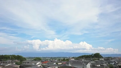 Timelapse of cumonimbus clouds growing over mountains and a residential area Stock Footage 338398562