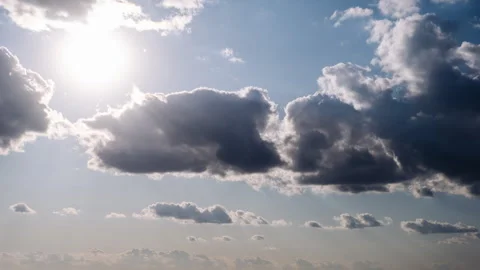 Timelapse of Cumulus Clouds Moving In The Blue Sky Against The Sun Stock Footage 253469265