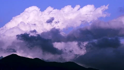 Timelapse of dark and bright clouds moving at the top of a mountain Stock Footage 132825609