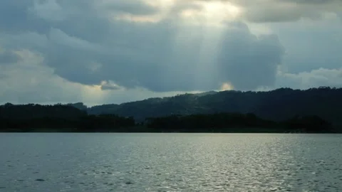 Timelapse of dark cloud movement and sunlight above the lake Stock Footage 320029369