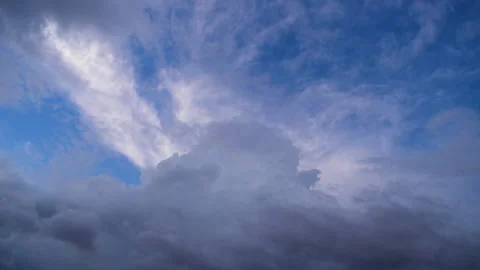 Timelapse of dark clouds filling in on white clouds in a blue sky Stock Footage 248734881