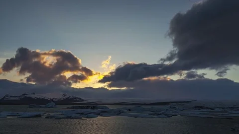 Timelapse of dark clouds moving over the glaceries and lagoon during sunset Stock Footage 73011597