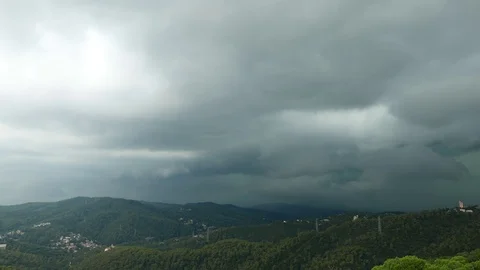 Timelapse dark heavy clouds drift over sky, Barcelona mountains panorama Stock Footage 99686899