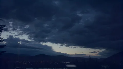Timelapse - dark storm clouds fade to black over town light, 4k Stock Footage 253814241