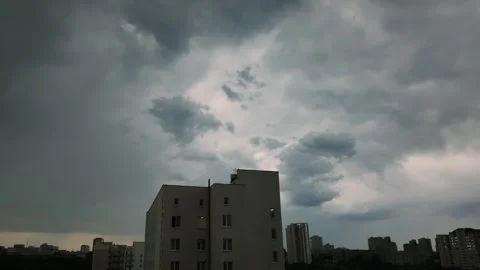 Timelapse of dark storm clouds moving over city residential buildings durin.. Stockbeeldmateriaal 339613694