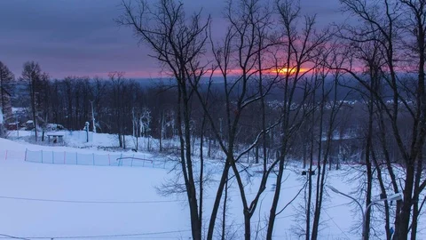 TIMELAPSE: Dawn on a training ski slope in winter. Colorful red sun Stock Footage 83459067