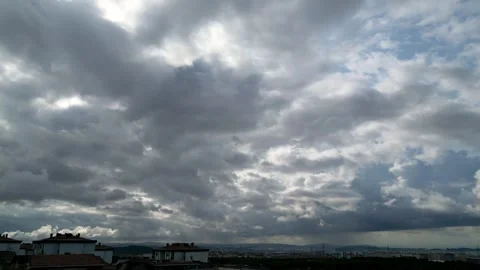 Timelapse of dense grey overcast clouds moving over a distant cityscape 스톡 동영상 347926771