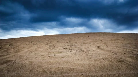 Timelapse of desert landscape under dark clouds at sunset. Video stock 68958700