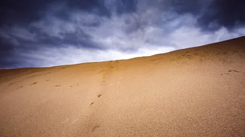 Timelapse of desert landscape under dark clouds at sunset. 動画素材 68961275