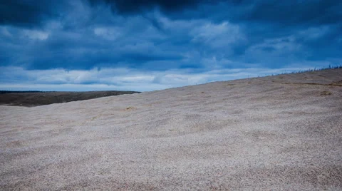 Timelapse of desert landscape under dark clouds at sunset. Stock Footage 68963415