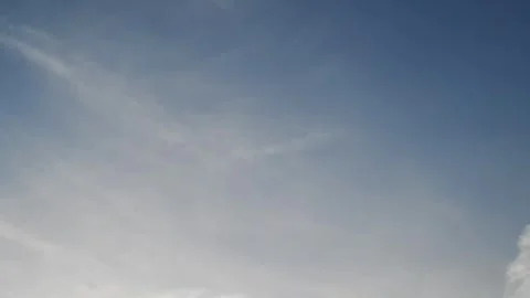Timelapse of diffuse white clous slowly moving across a pale blue summer sky Stock Footage 310215151