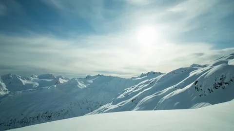 Timelapse of dispersed clouds floating across sky above snow covered mountains Stock Footage 124238777