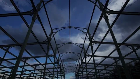 Timelapse of dramatic clouds moving over a historic iron auction hall structure Stock Footage 312818636