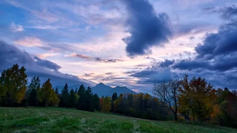 Timelapse of Dramatic Clouds Moving Over Mountain Meadow at Sunset 動画素材 319832906