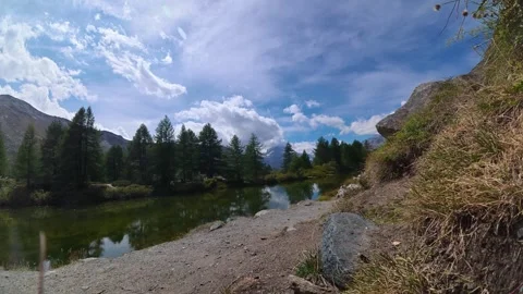 Timelapse of Dramatic Clouds Rolling Over Serene Swiss Alps Lake Landscape Видео 347344480