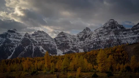 Timelapse, dramatic dark clouds moving above snowy peaks and larch valley Stock Footage 168457548