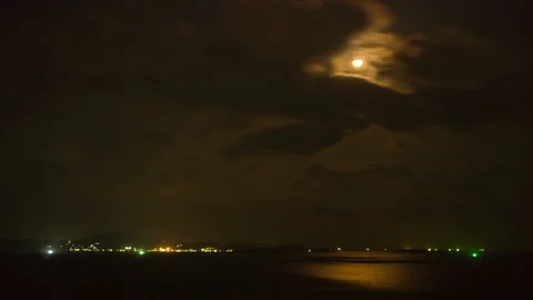 Timelapse of dramatic panorama of bright moon at sea in Thailand. Mysterious Stock Footage 93189317