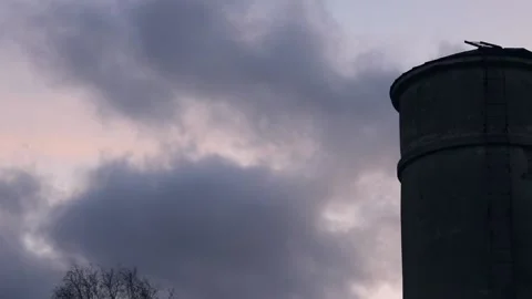 Timelapse dramatic sunset clouds and desolate industrial silo Stock Footage 170389492
